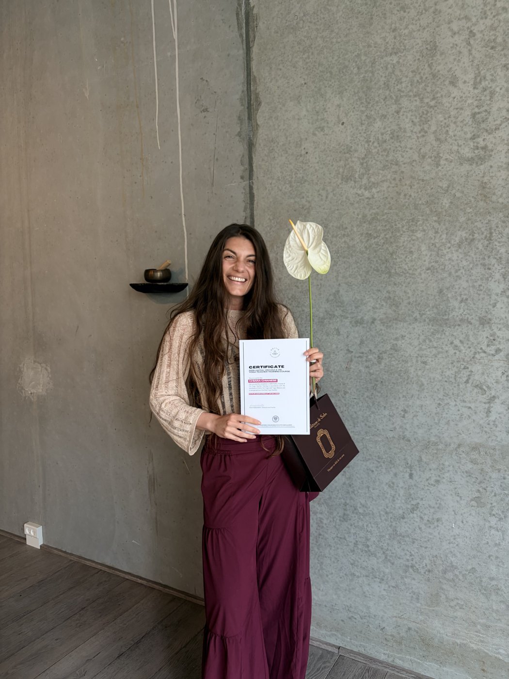 Chiara holding her 200-hour Yoga Teacher Training certificate in Copenhagen